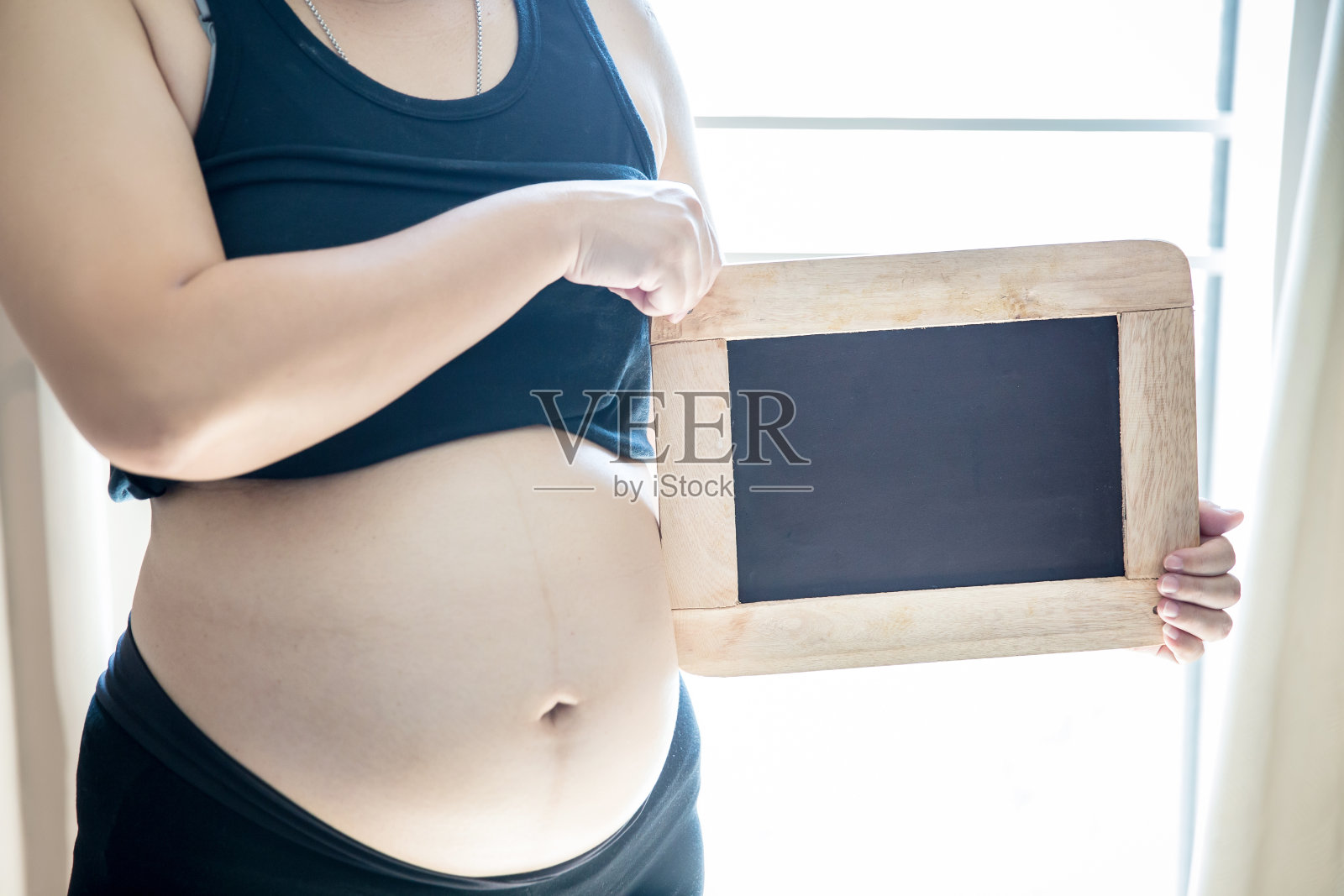 孕妇拿着小黑黑板。常见问题的概念。计划和提醒孕妇概念。照片摄影图片