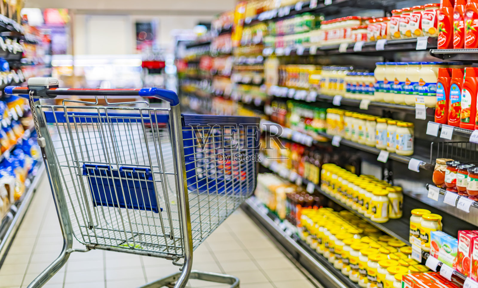 超市货架旁的购物车照片摄影图片