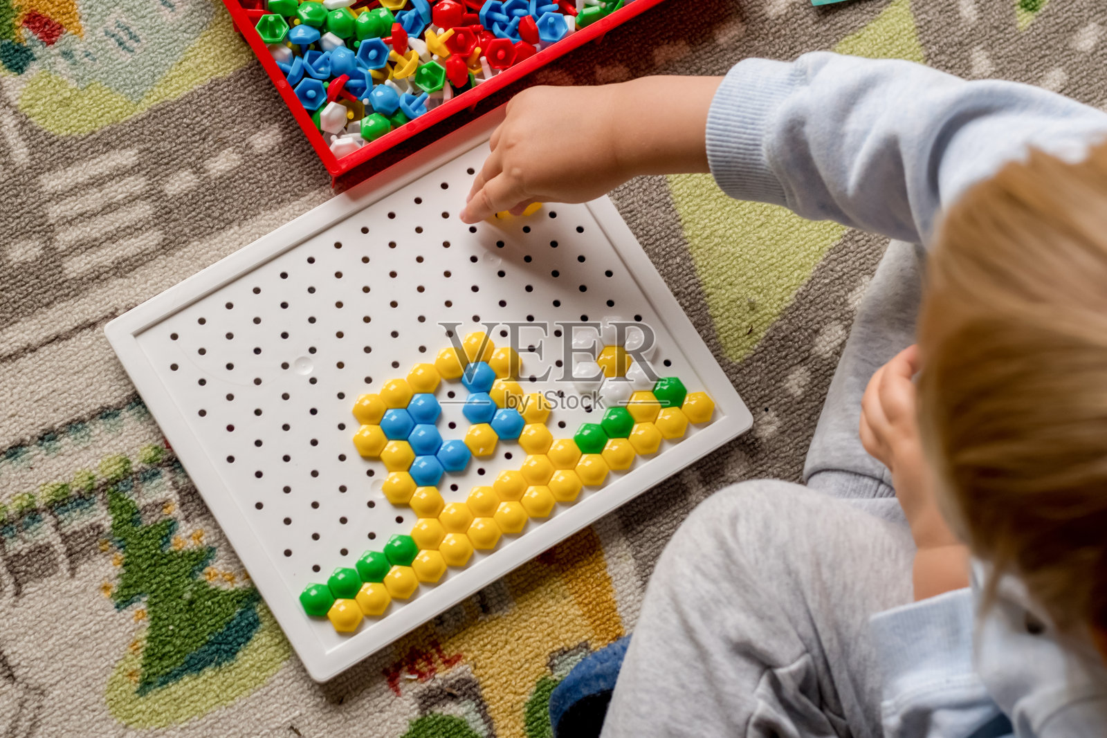 幼儿玩钉板马赛克。儿童早期发展。精细运动技能。学习和创新照片摄影图片