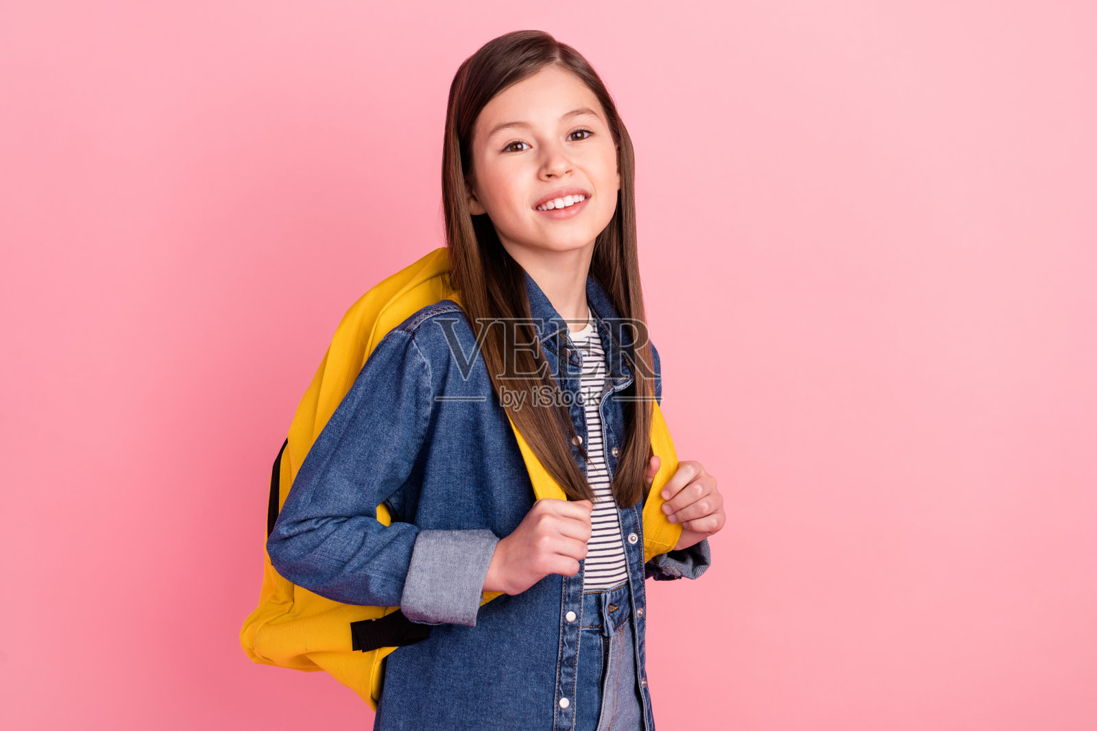 照片肖像的小女孩可爱微笑的背包孤立在粉彩粉红色的背景照片摄影图片