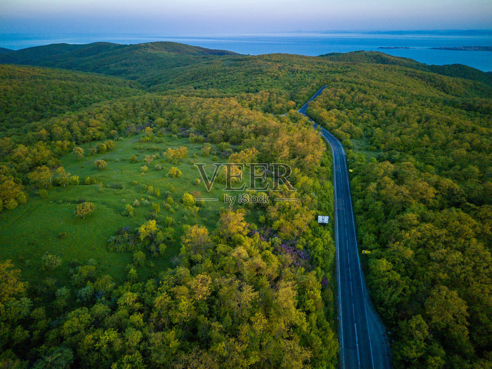 道路上有汽车和卡车，通向巴尔干山脉的森林之间的距离。照片摄影图片