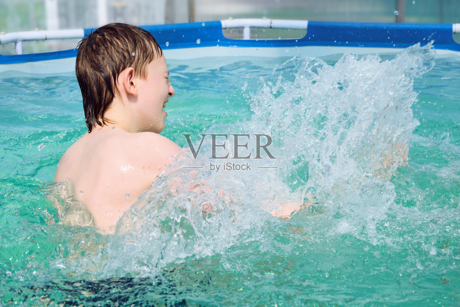 快乐的男孩在夏天的游泳池里戏水，进行有趣的休闲活动照片摄影图片