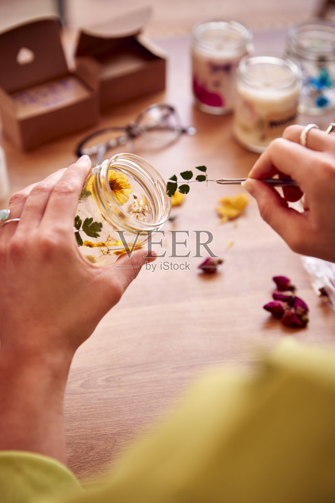 特写的女人制作精品花蜡烛出售在线在家工作照片摄影图片