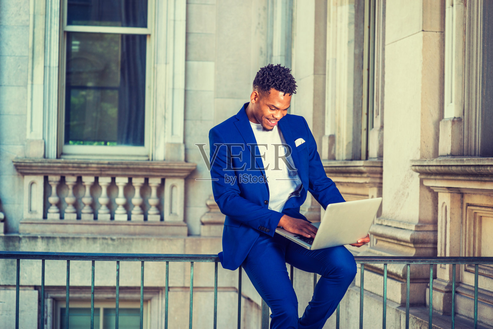 一个年轻人在纽约办公大楼外用笔记本电脑工作照片摄影图片