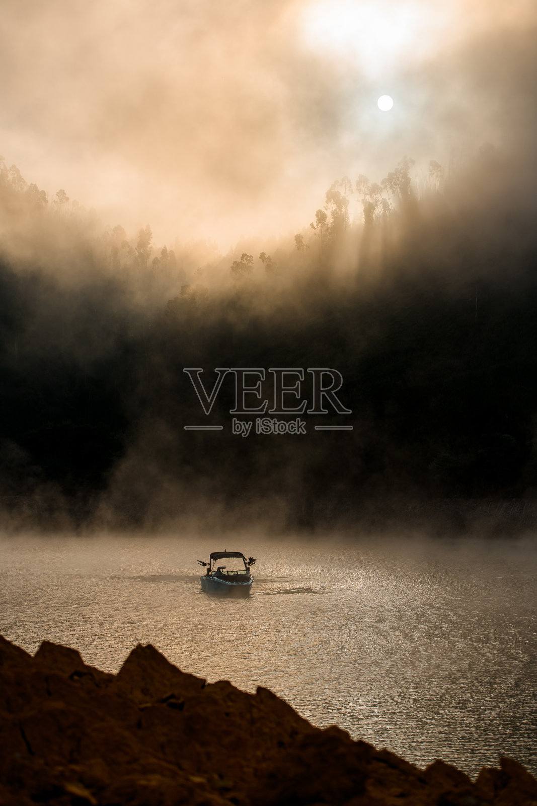 阳光、雾、山丘和水上摩托艇的美丽景色令人惊叹照片摄影图片