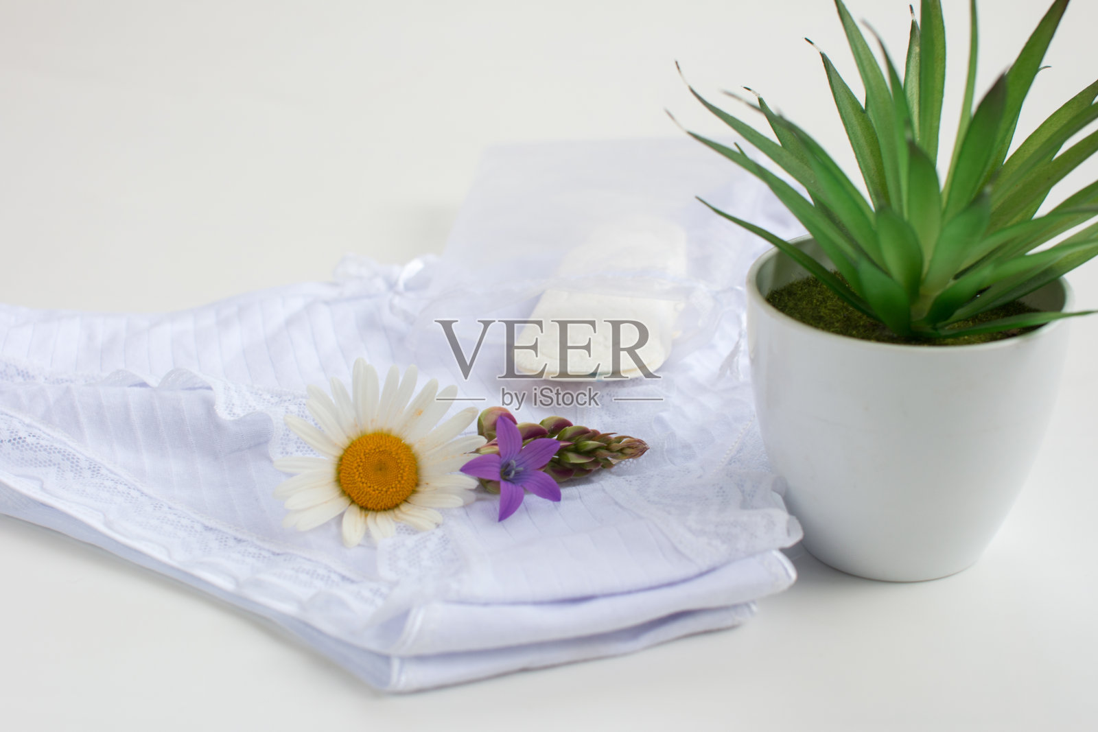 女人的内衣滑落。每天用洋甘菊卫生巾照片摄影图片