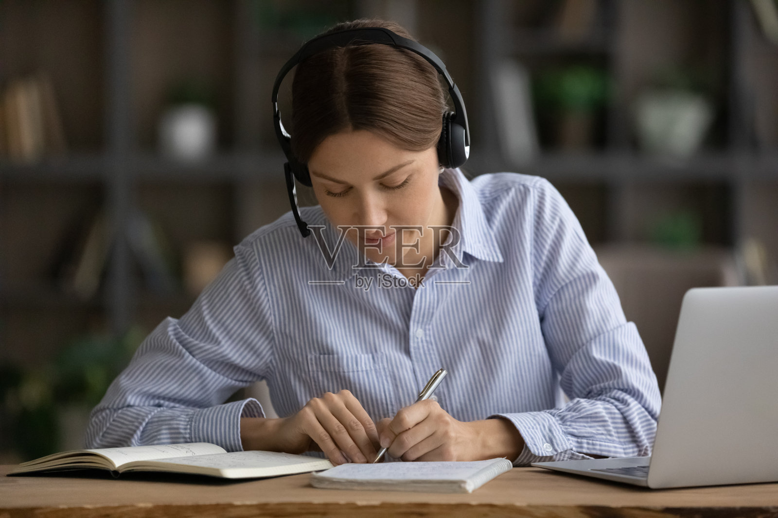 女性戴耳机注意，同时研究使用笔记本电脑视频通话照片摄影图片