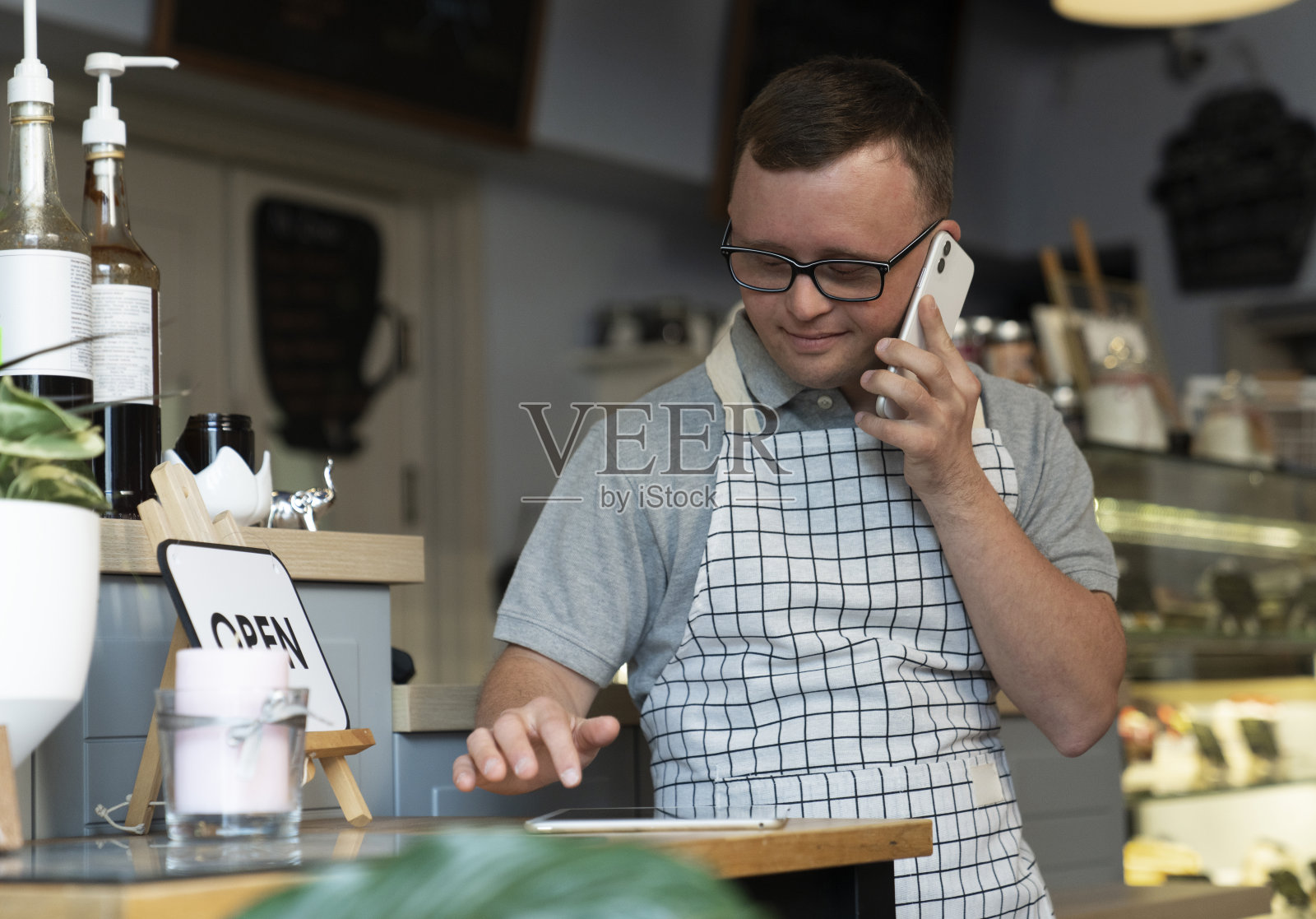 年轻的白人女服务员在厨房里使用手机照片摄影图片