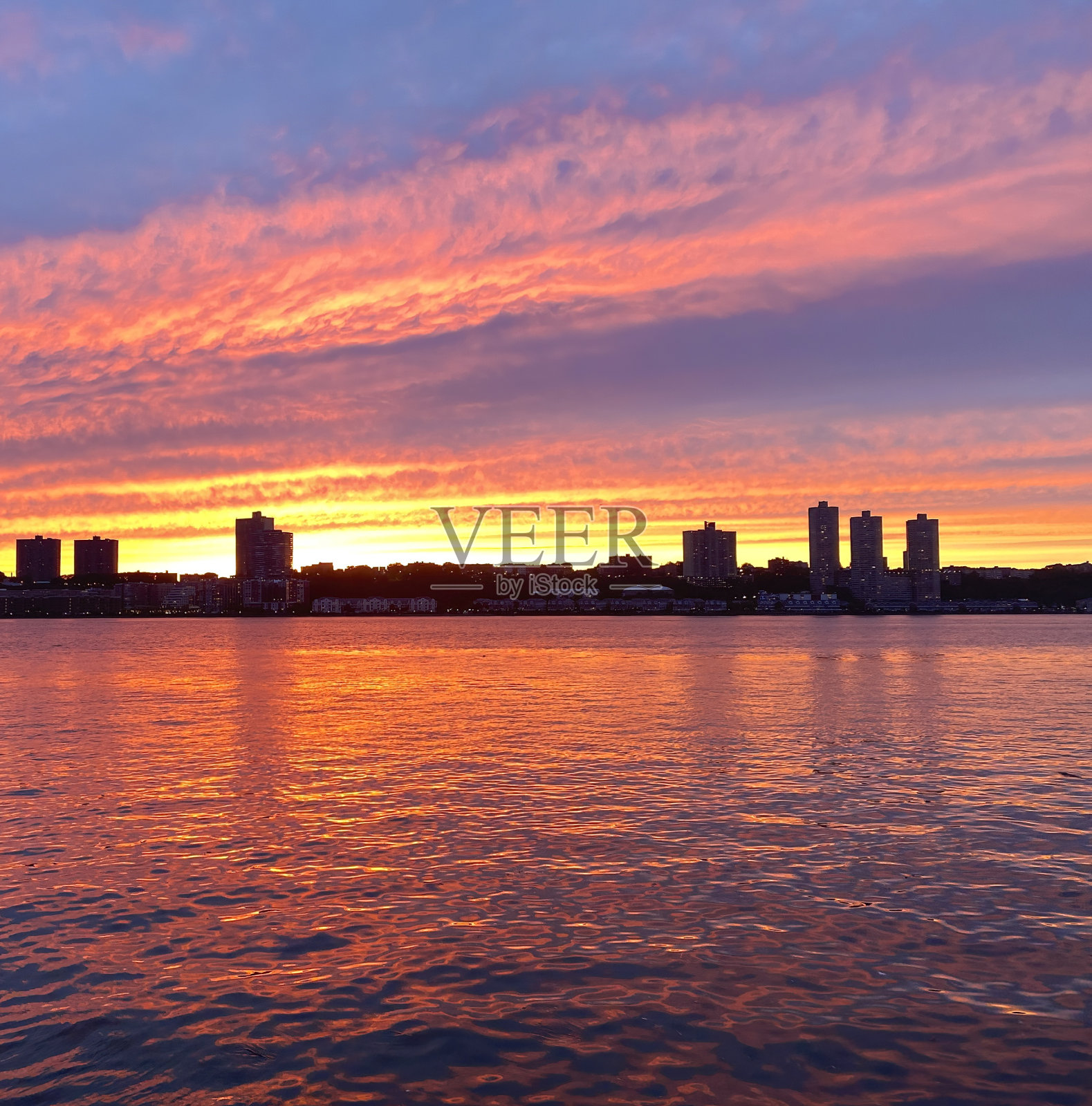 哈德逊河上强烈的橙色和紫色的日落照片摄影图片