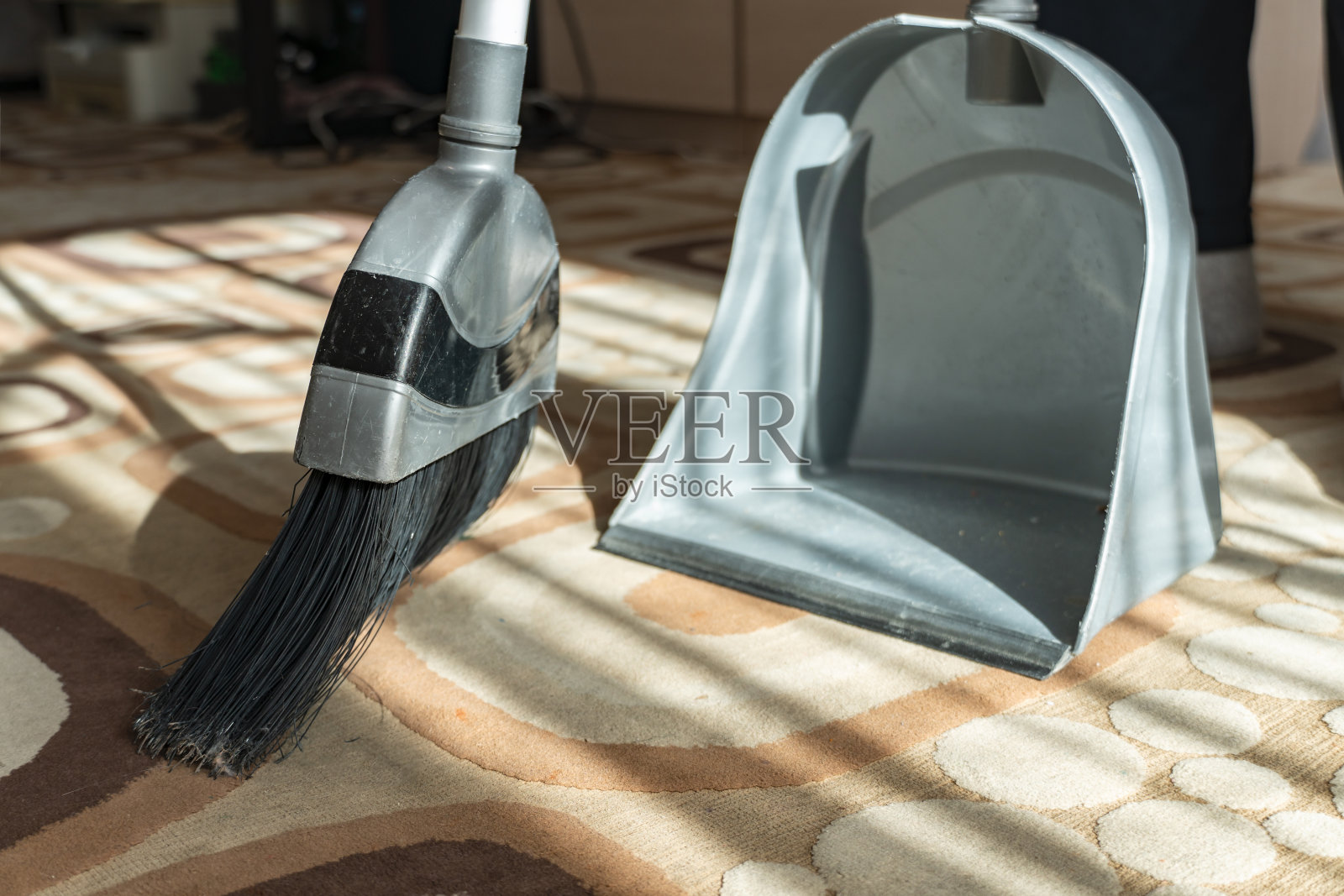 用刷子把地板上的灰尘扫掉。尘土飞扬。用簸箕把地毯上的灰尘扫掉。打扫房子。做清洁。特写镜头。清洁服务。家里清洁程序。照片摄影图片