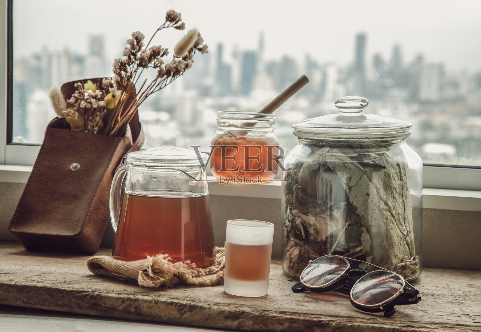 中式凉茶(Jub Lieng)加蜂蜜，放在旧木桌上，与城市景色相映成趣。照片摄影图片