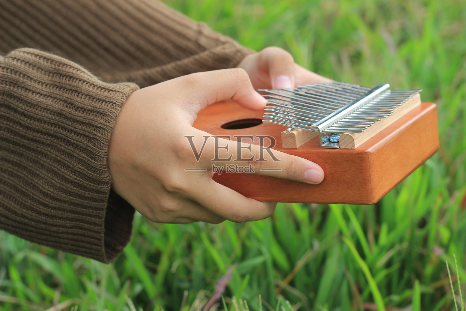 照片女孩手弹卡利姆巴，非洲原声乐器照片摄影图片