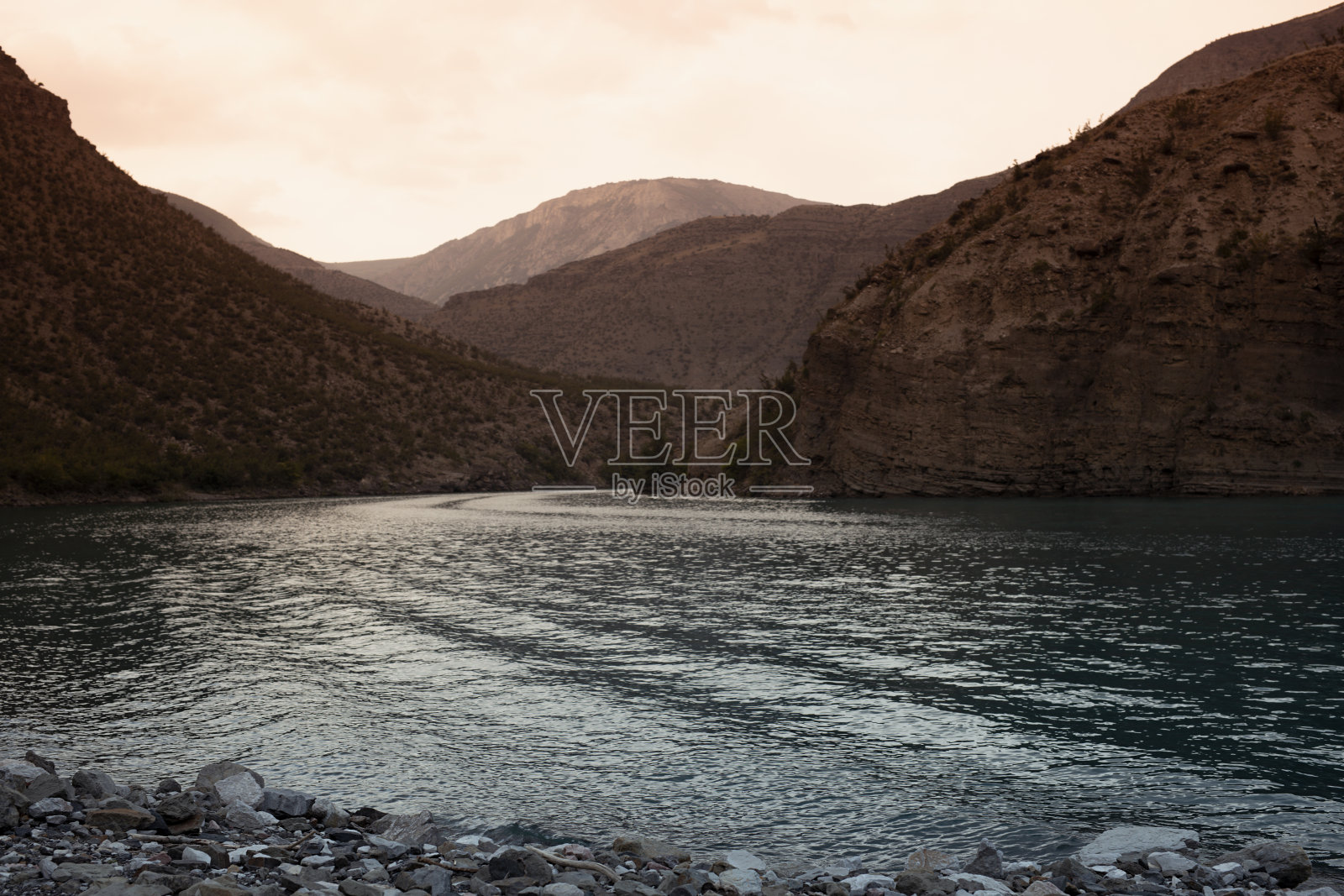 山河苏拉克在夕阳下与山脊峡谷在阳光下，明亮的微风波在水上，卵石海岸。达吉斯坦高加索山地景观，探险，旅游，野外旅游。照片摄影图片