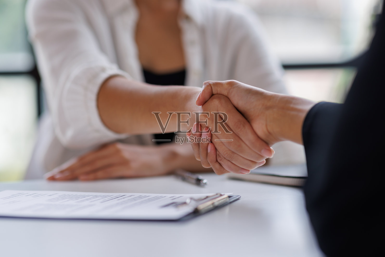 商务人士在办公室握手或握手。成功的面试。向银行申请贷款。推销员、银行职员或律师为交易、协议或销售而握手。增加工资。照片摄影图片