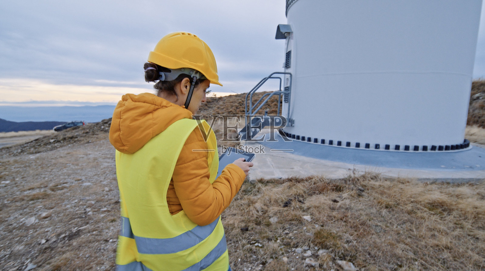 在风电场工作的女性风能工程师。可再生能源系统。碳中和和可持续能源。照片摄影图片