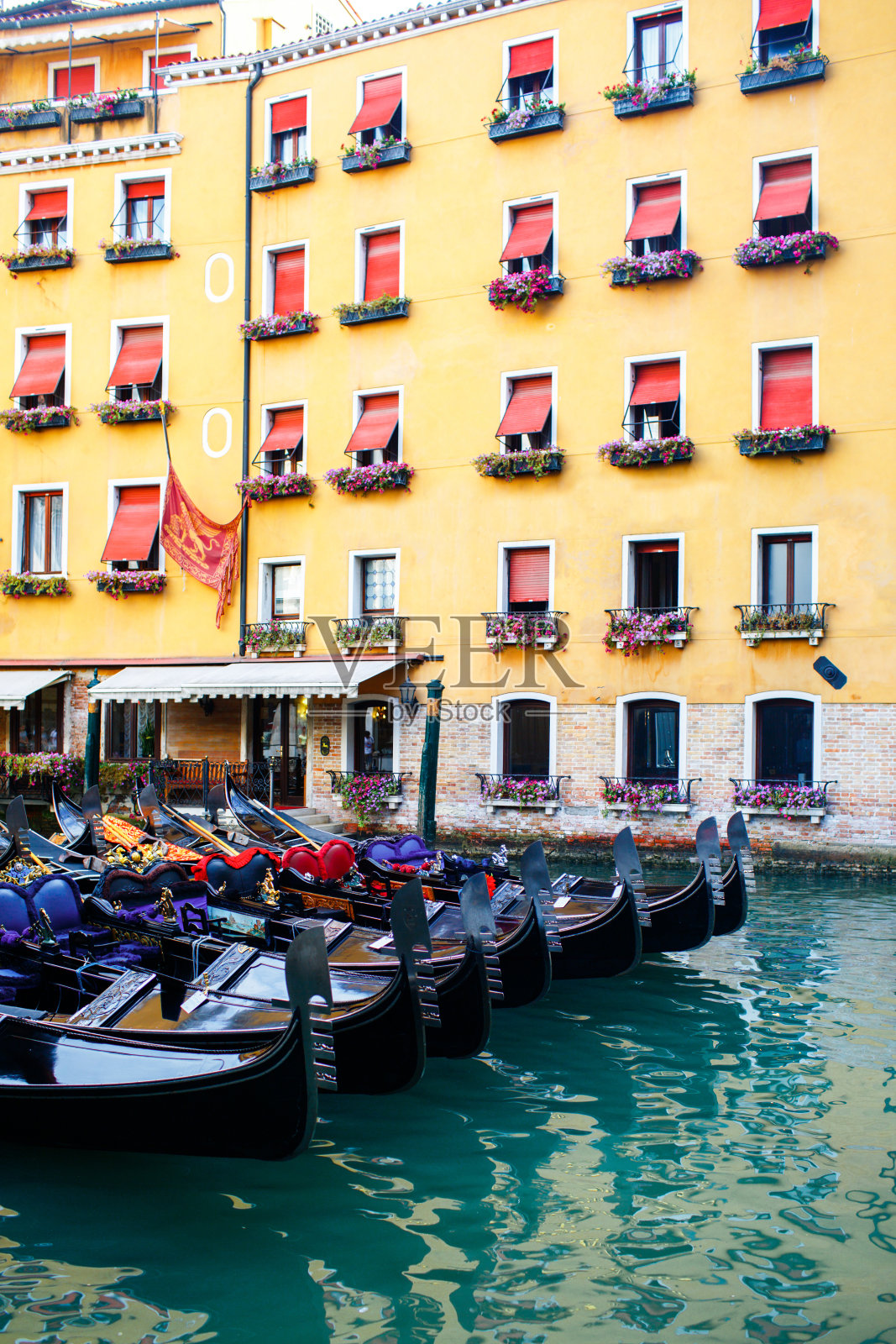 意大利威尼斯，彩色房子附近的一排甘多尔照片摄影图片