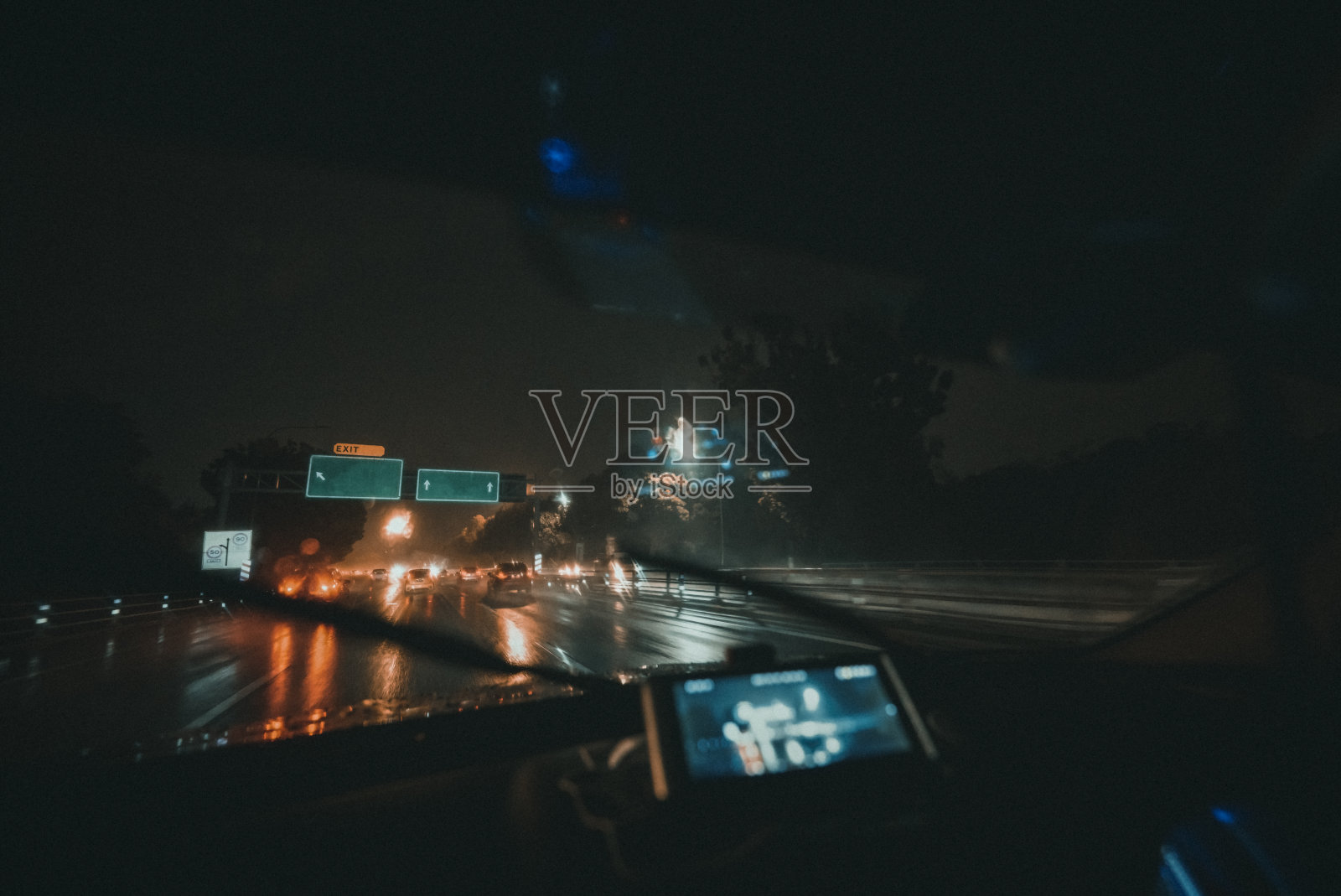 汽车的观点，驾驶在夜间的雨与雨刷打开在高速公路照片摄影图片