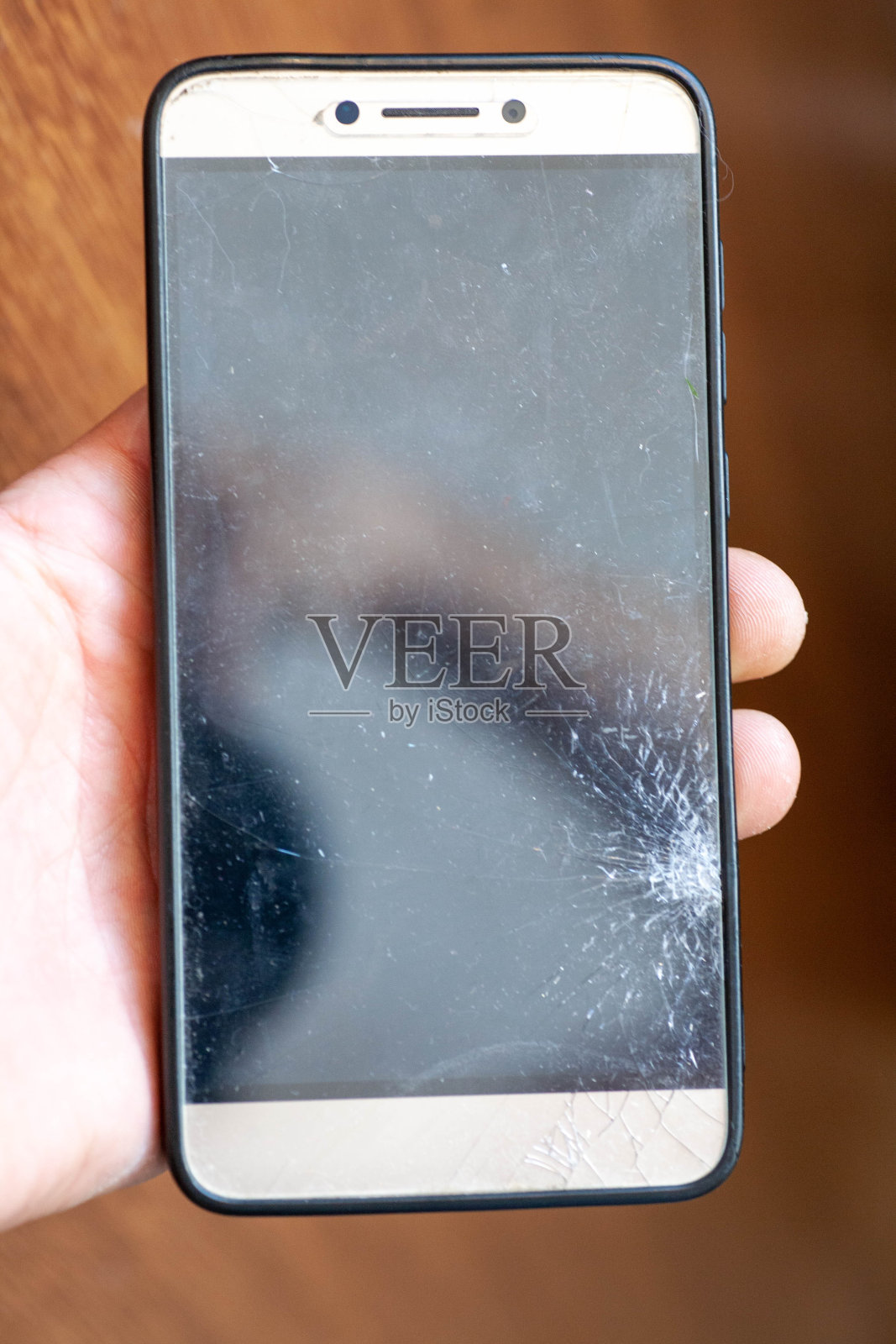 木桌上智能手机的碎玻璃。有选择性的重点。照片摄影图片