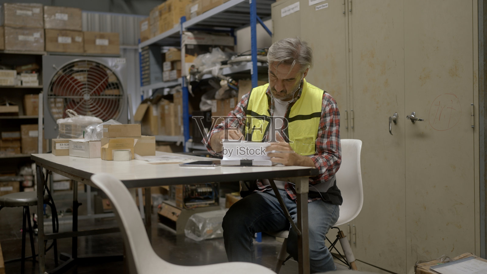 员工正在仓库检查货物。照片摄影图片