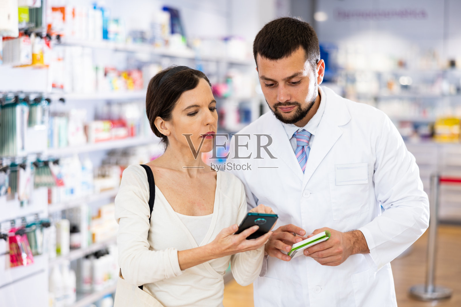 男药剂师在药店咨询女顾客照片摄影图片
