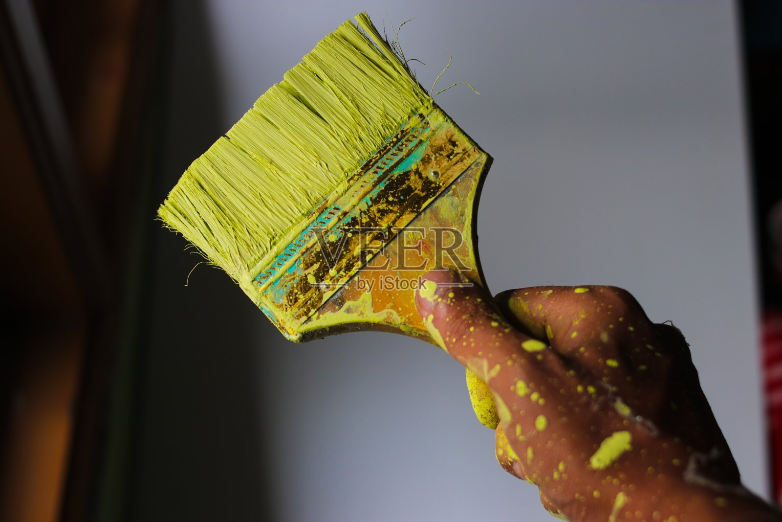 手拿着肮脏的画笔与模糊的背景照片摄影图片
