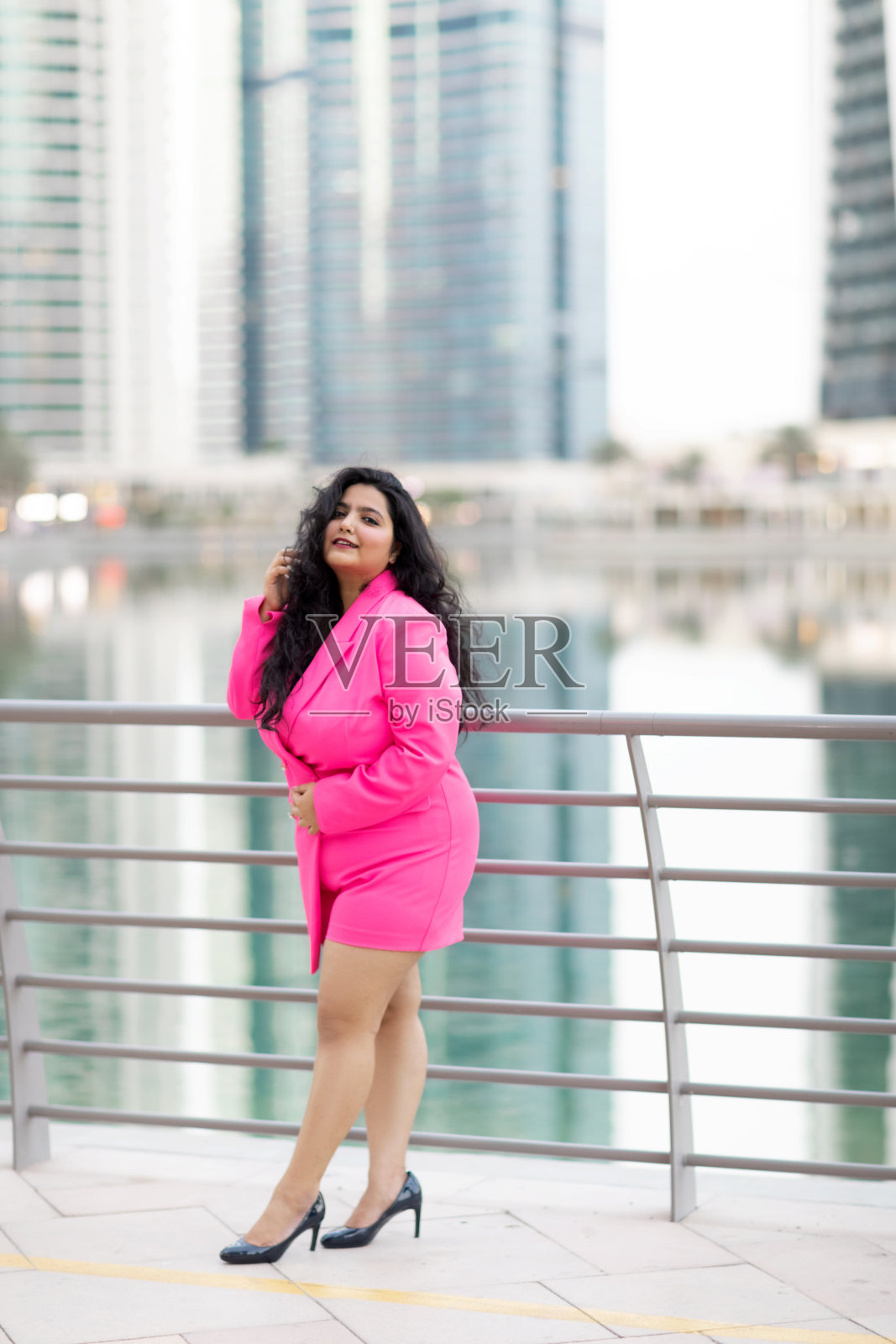 身着优雅套装的现代印度女子在迪拜码头堤岸上微笑照片摄影图片