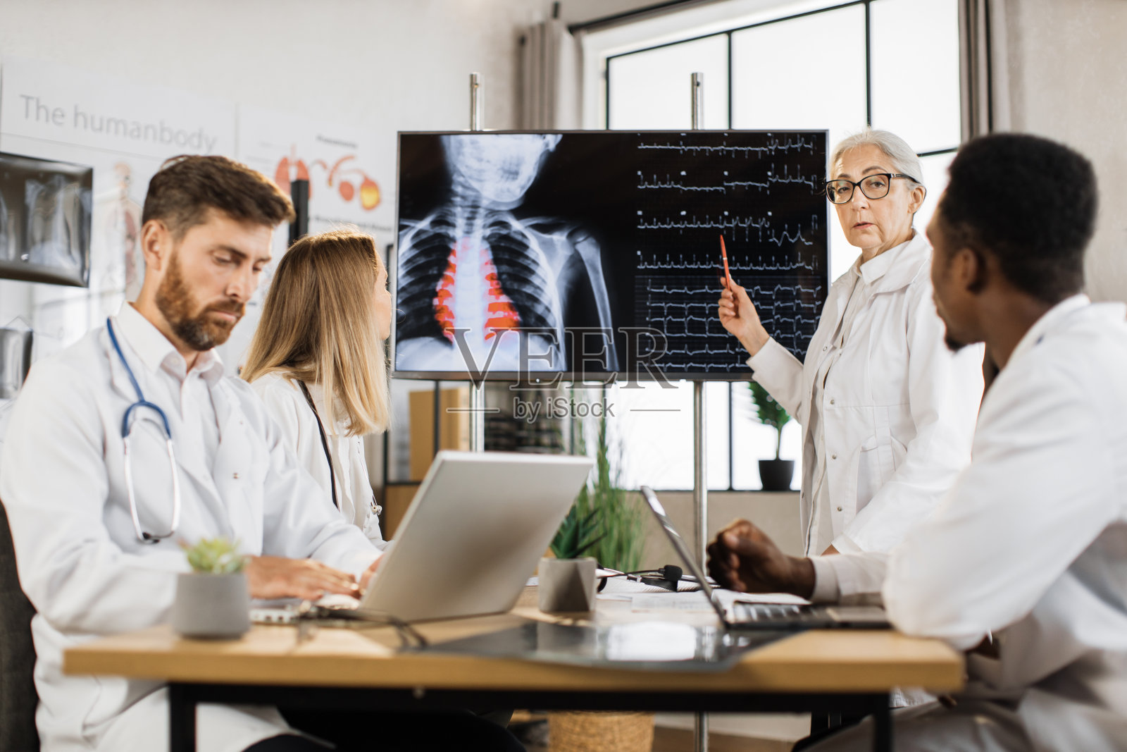 向不同医生介绍x光扫描结果照片摄影图片