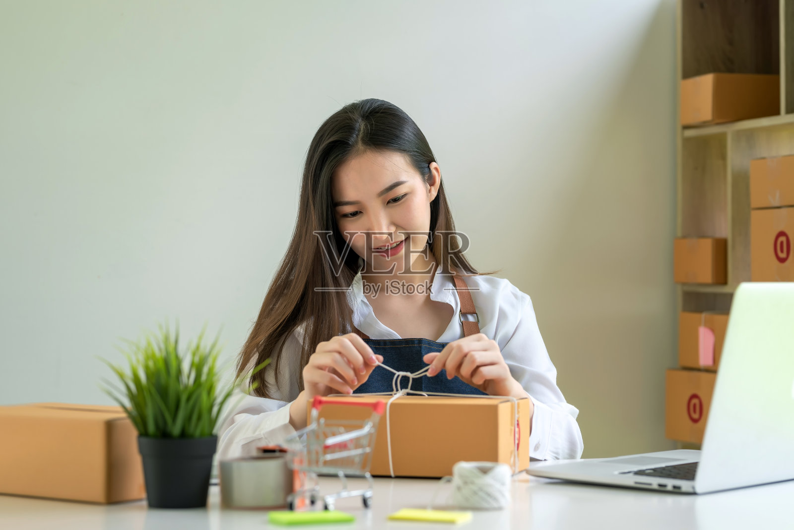美丽的亚洲商人很高兴交付在线产品给客户。在家工作的概念。照片摄影图片