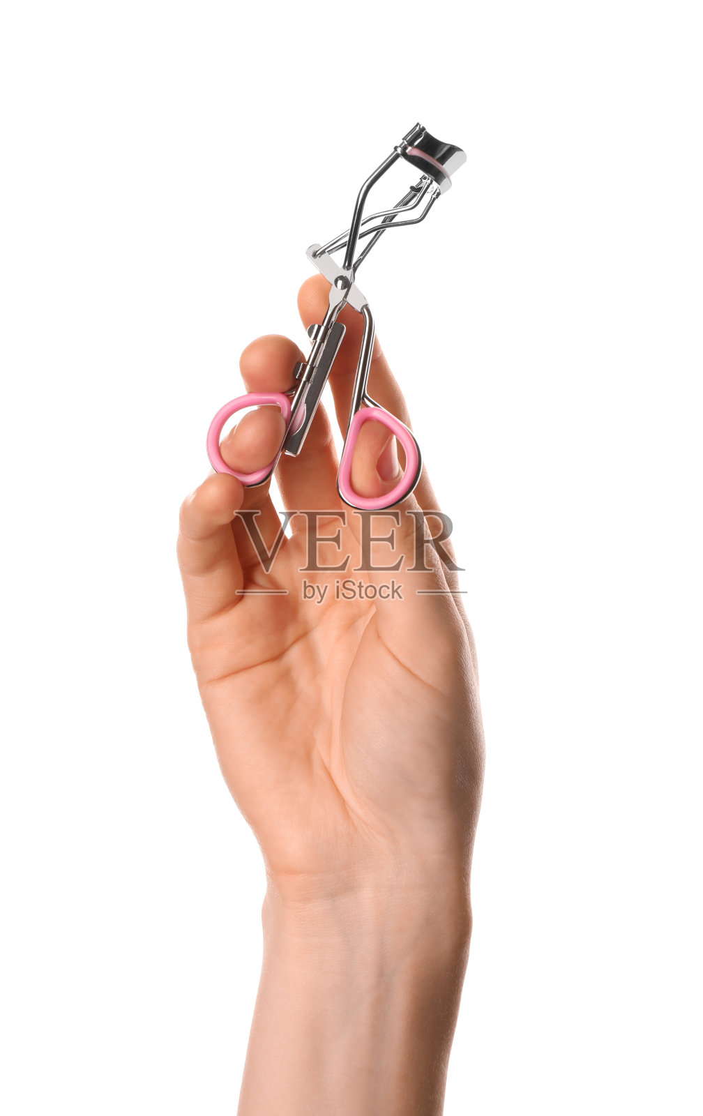 女人拿着睫毛夹在白色背景，特写。化妆工具照片摄影图片