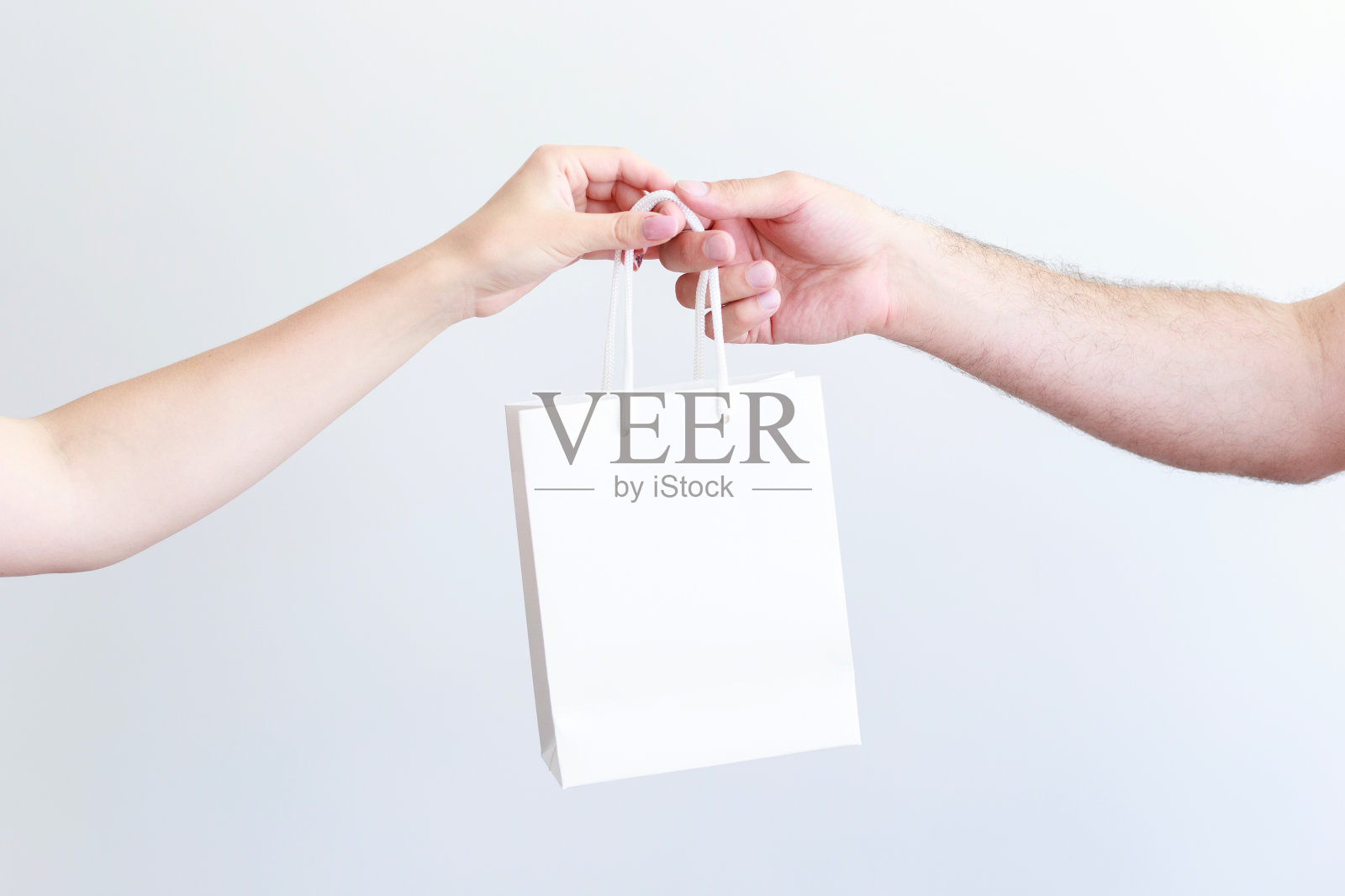 白色工艺包在一个男人和一个女人的手特写照片摄影图片