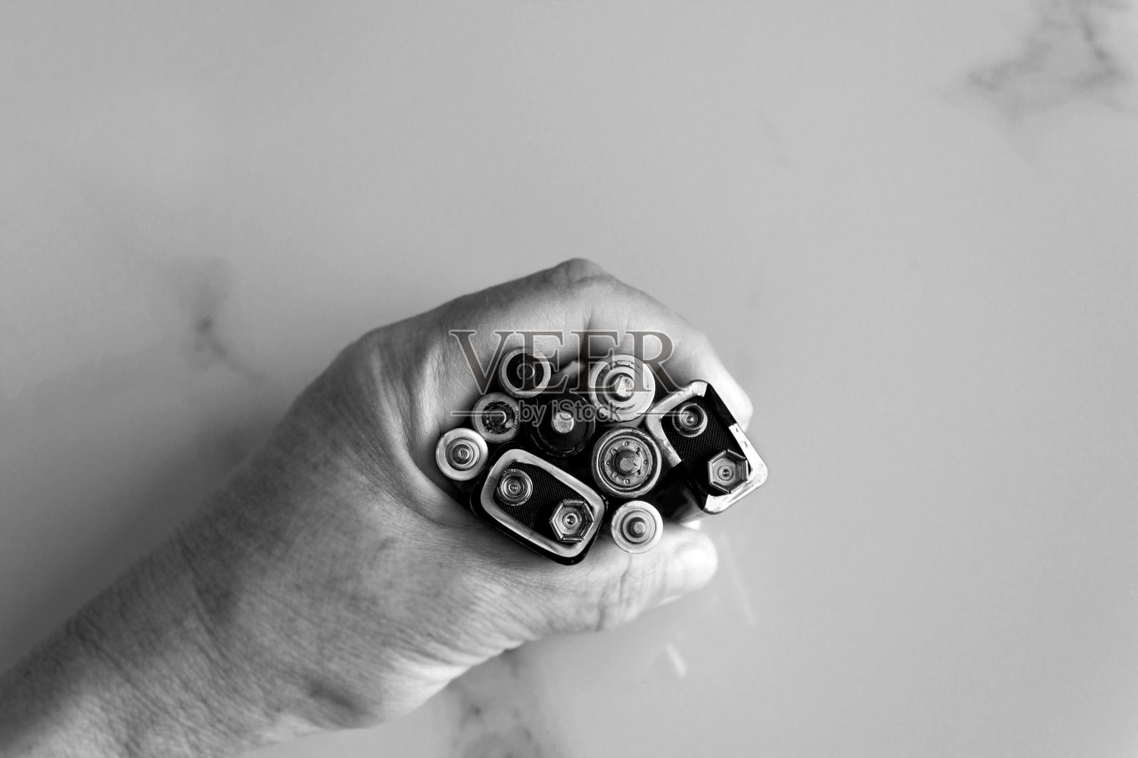 特写女性的手拿着用过的碱性电池堆。废弃电池及蓄电池的处理。概念——循环利用、一次性能源、电力、环境和生态。照片摄影图片