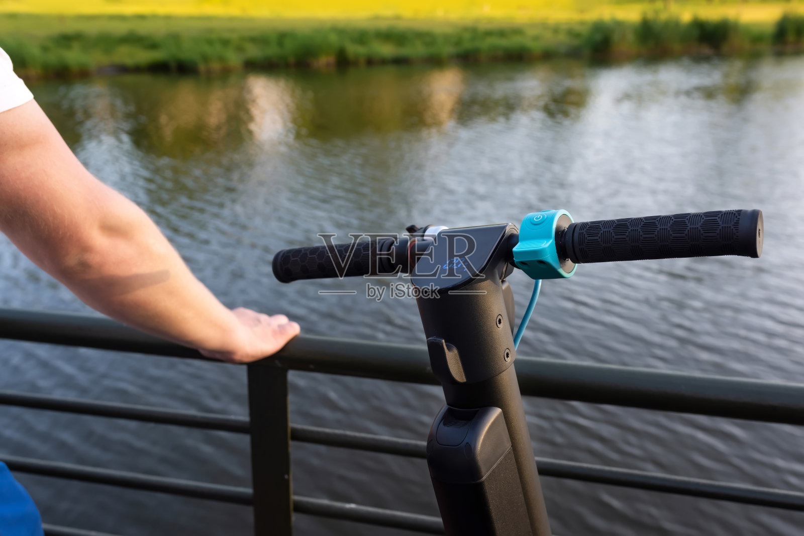 公园里的电动滑板车的特写，背景是一个湖。城市生活方式，可持续交通照片摄影图片