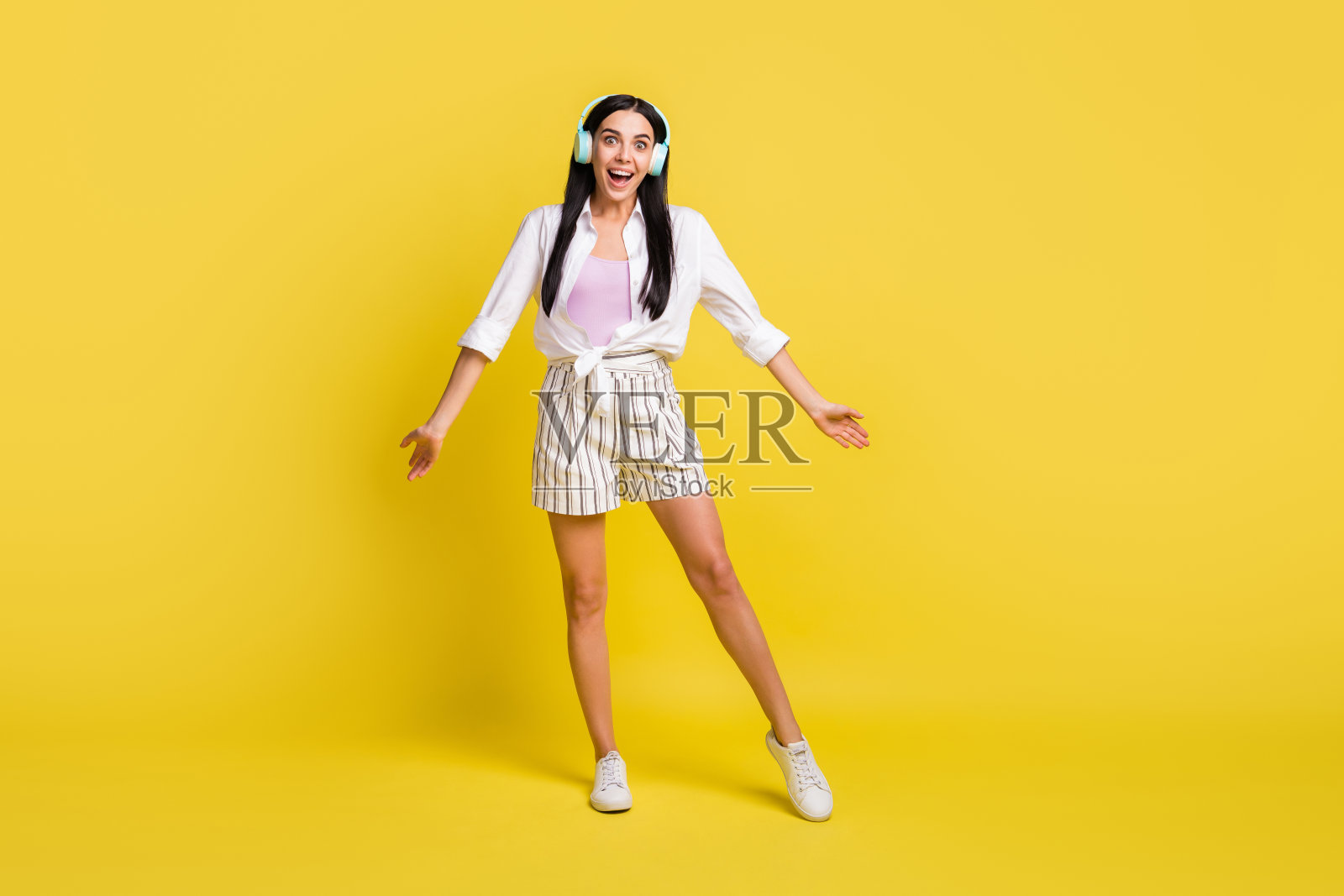 全长照片兴奋快乐的年轻女子音乐爱好者戴耳机隔离的黄色背景照片摄影图片
