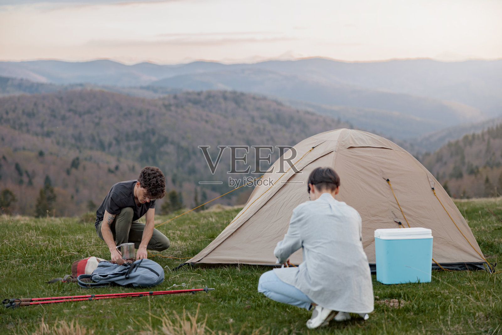 一对朋友在山里搭帐篷。令人惊叹的景观。旅行。照片摄影图片