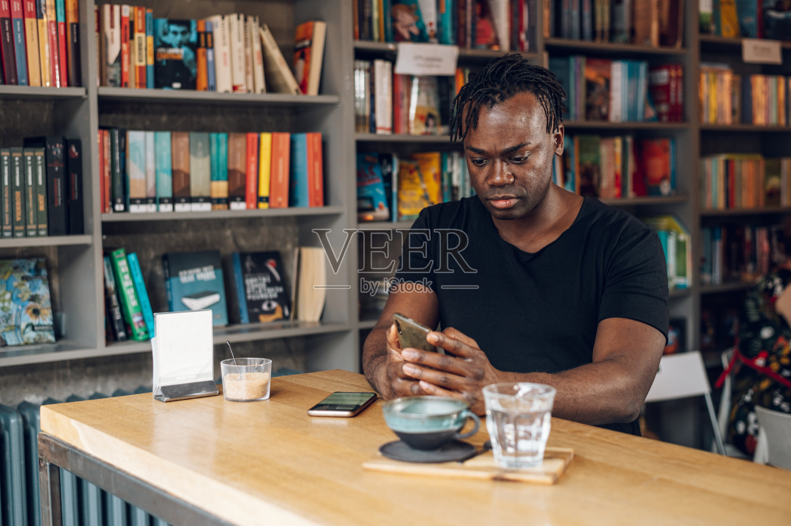 非洲裔美国男子在咖啡馆喝咖啡时使用智能手机照片摄影图片