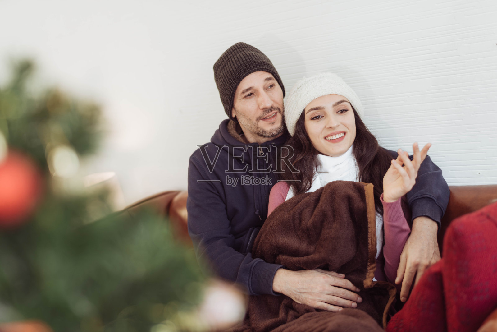 冬天的时候，年轻夫妇喜欢坐在一起看外面。情侣喜欢穿着毛衣一起享受，一起聊天。情人节之夜幸福的情侣。照片摄影图片