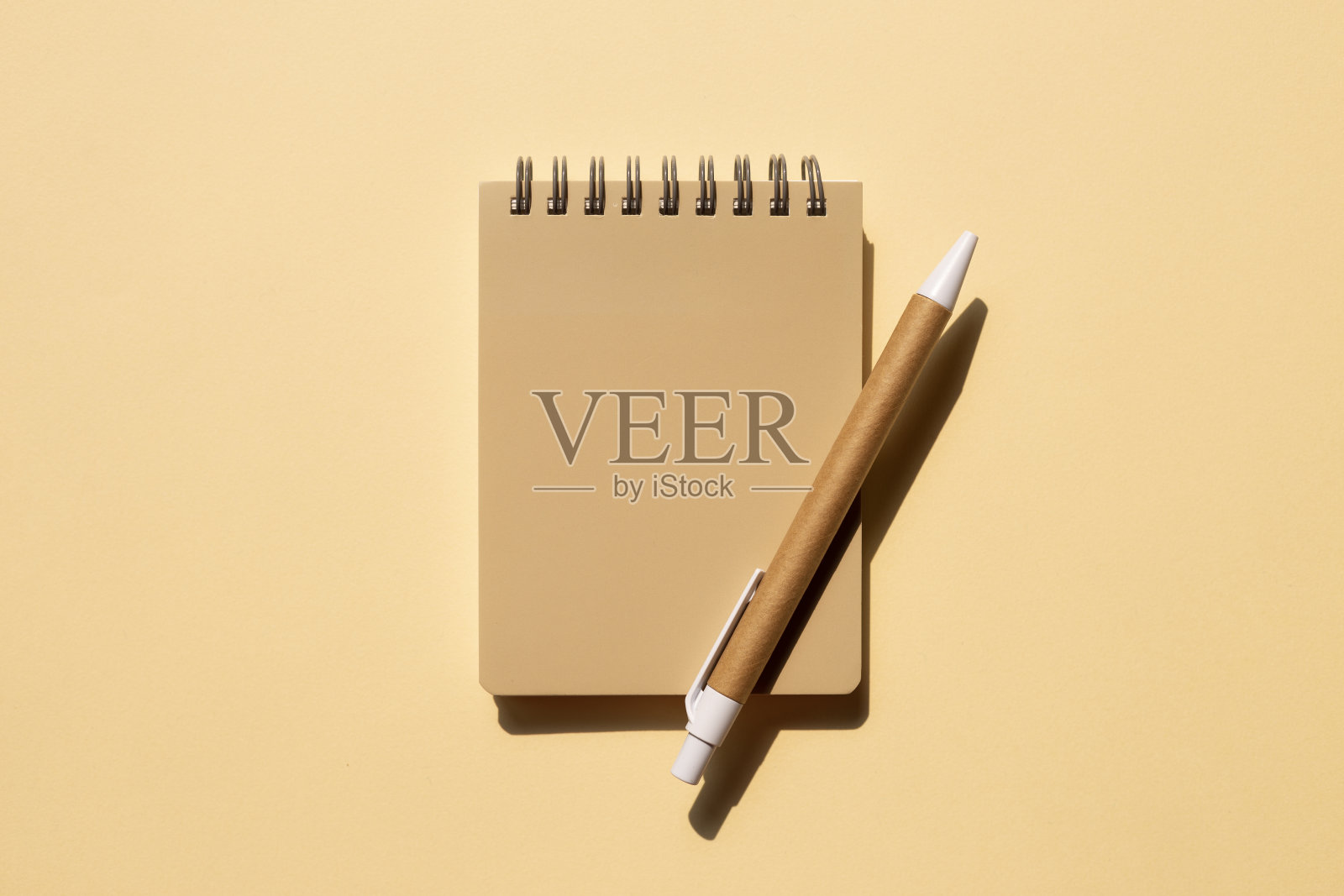 笔记本和笔在米色背景。俯视图，复制空间照片摄影图片