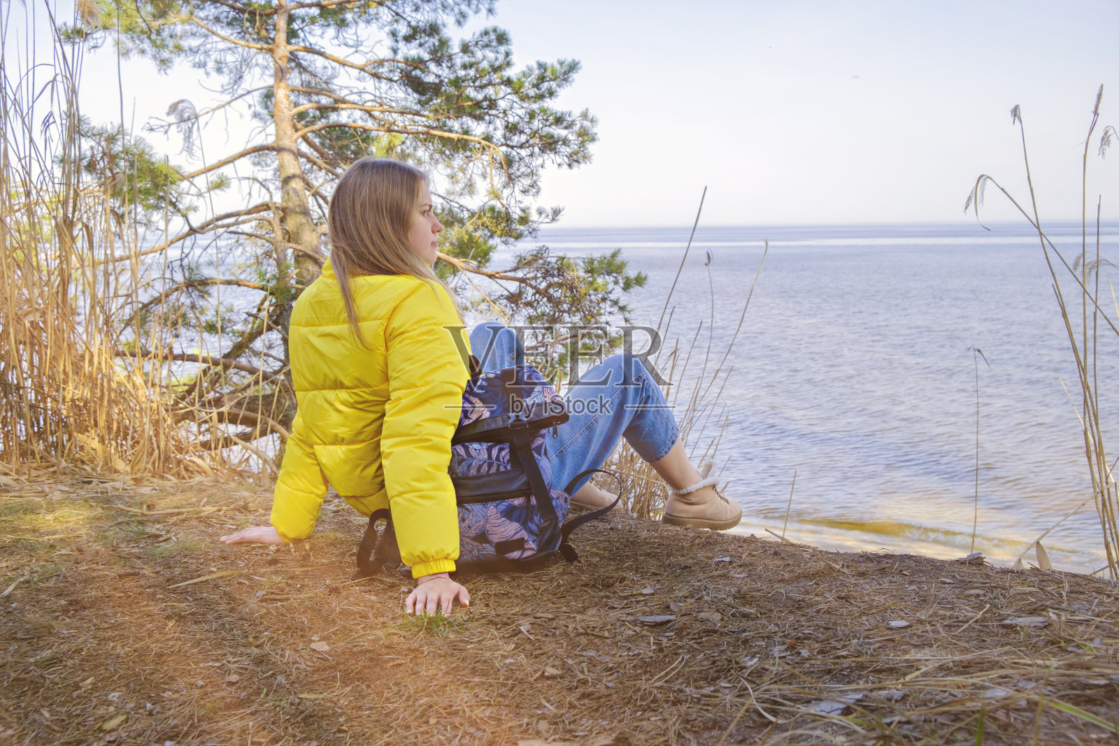 放松的年轻女孩坐在森林中风景如画的湖边，沉思自然。照顾心理健康。徒步旅行和徒步旅行。留给自己的时间，重启，冥想。照片摄影图片