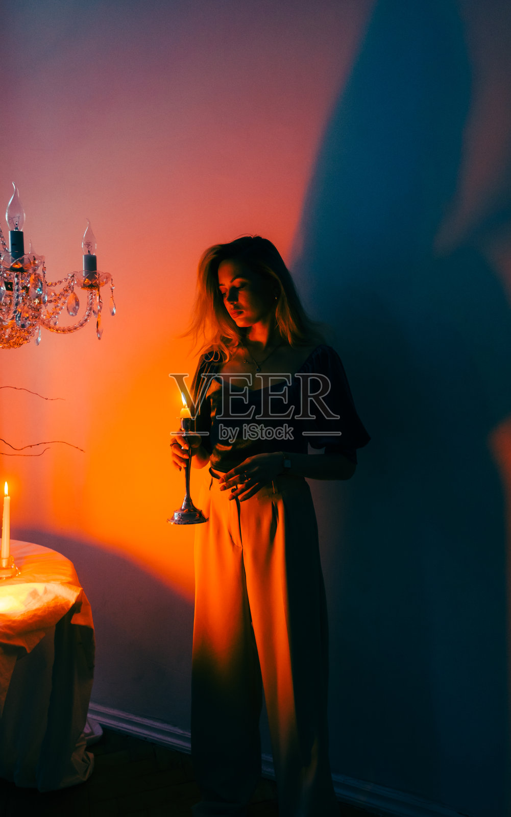 迷人的高加索女人的肖像烛台在黑暗，复古优雅的内部。照片摄影图片