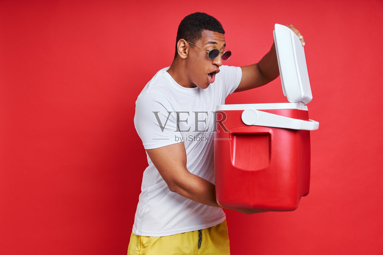 惊讶的混血男子看里面的冷却器照片摄影图片