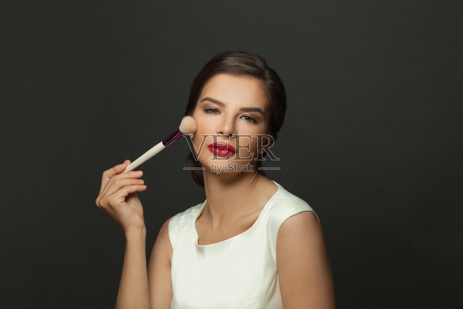 美丽的脸。用化妆刷涂抹腮红的美丽模特肖像。年轻女性，皮肤柔软光滑，妆容清新。皮肤的化妆品。照片摄影图片