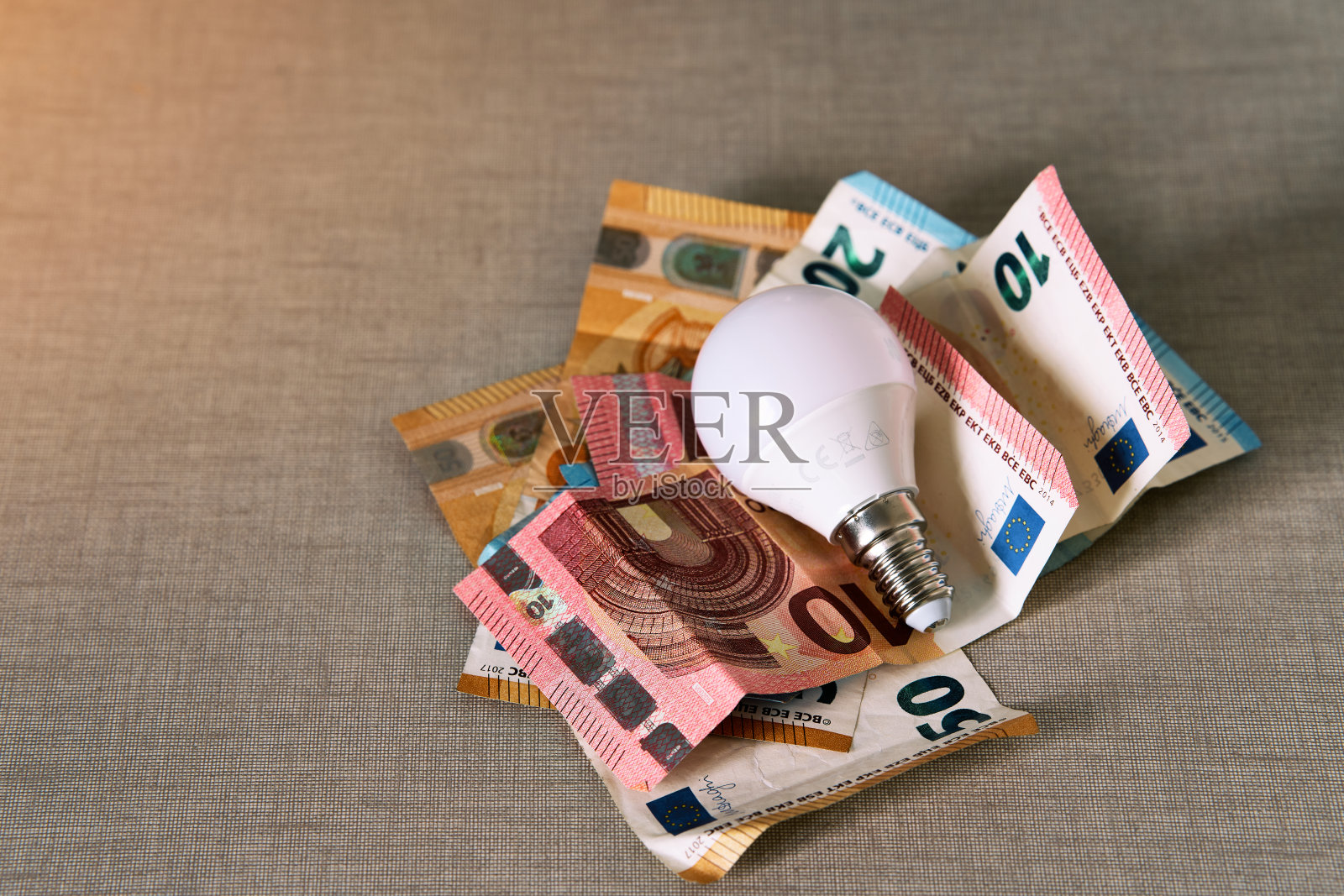 几张带有灯泡的欧元钞票代表了电价的上涨照片摄影图片
