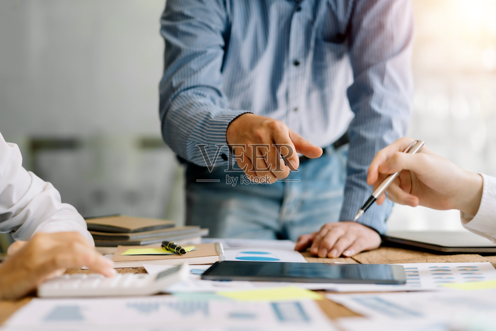 业务团队在会议上一起计划投资。近距离观察商务人士顾问指着图表和分析财务报告。照片摄影图片