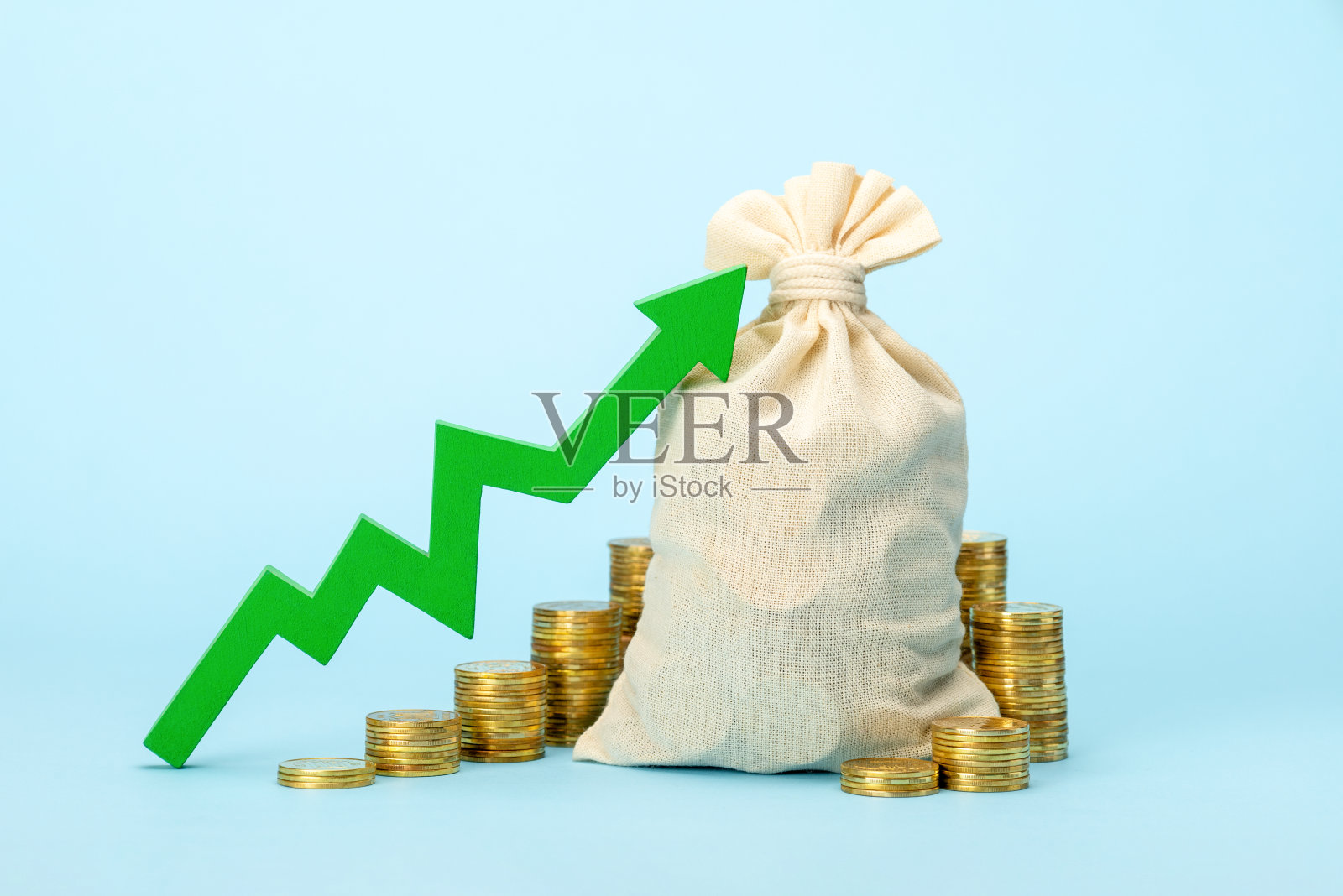 蓝色背景上的钱袋和绿色向上箭头照片摄影图片