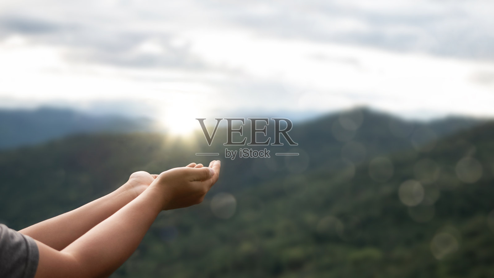 有宗教信仰的双手祈祷，有上帝祝福的背景。希望、爱和奉献的力量。照片摄影图片