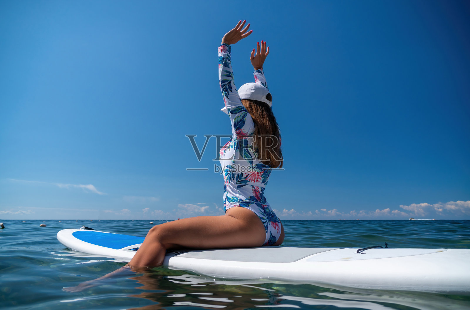 健康快乐的比基尼健身女人放松在sup冲浪板，漂浮在清澈的蓝绿色海水。休闲运动。站立式桨板冲浪。夏天好玩，假期旅游。积极的生活方式照片摄影图片