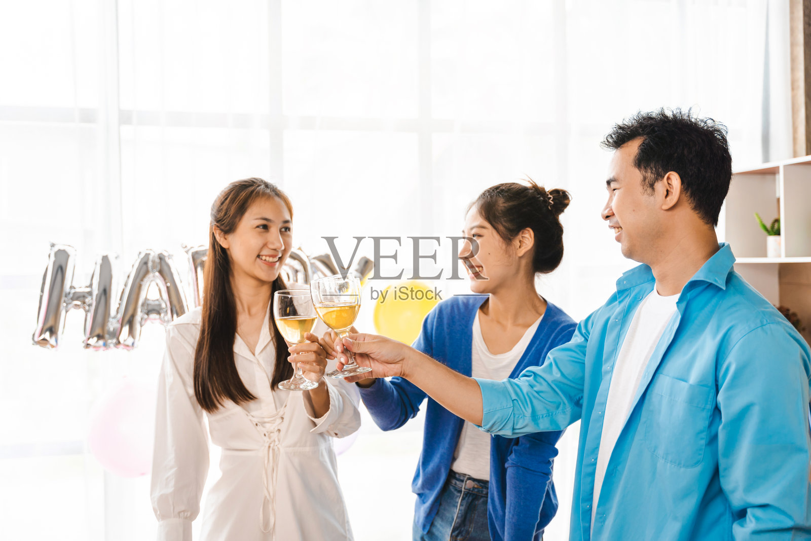 快乐的亚洲人吃着披萨，在合作办公室喝着白葡萄酒欢呼。外卖和团队合作理念照片摄影图片