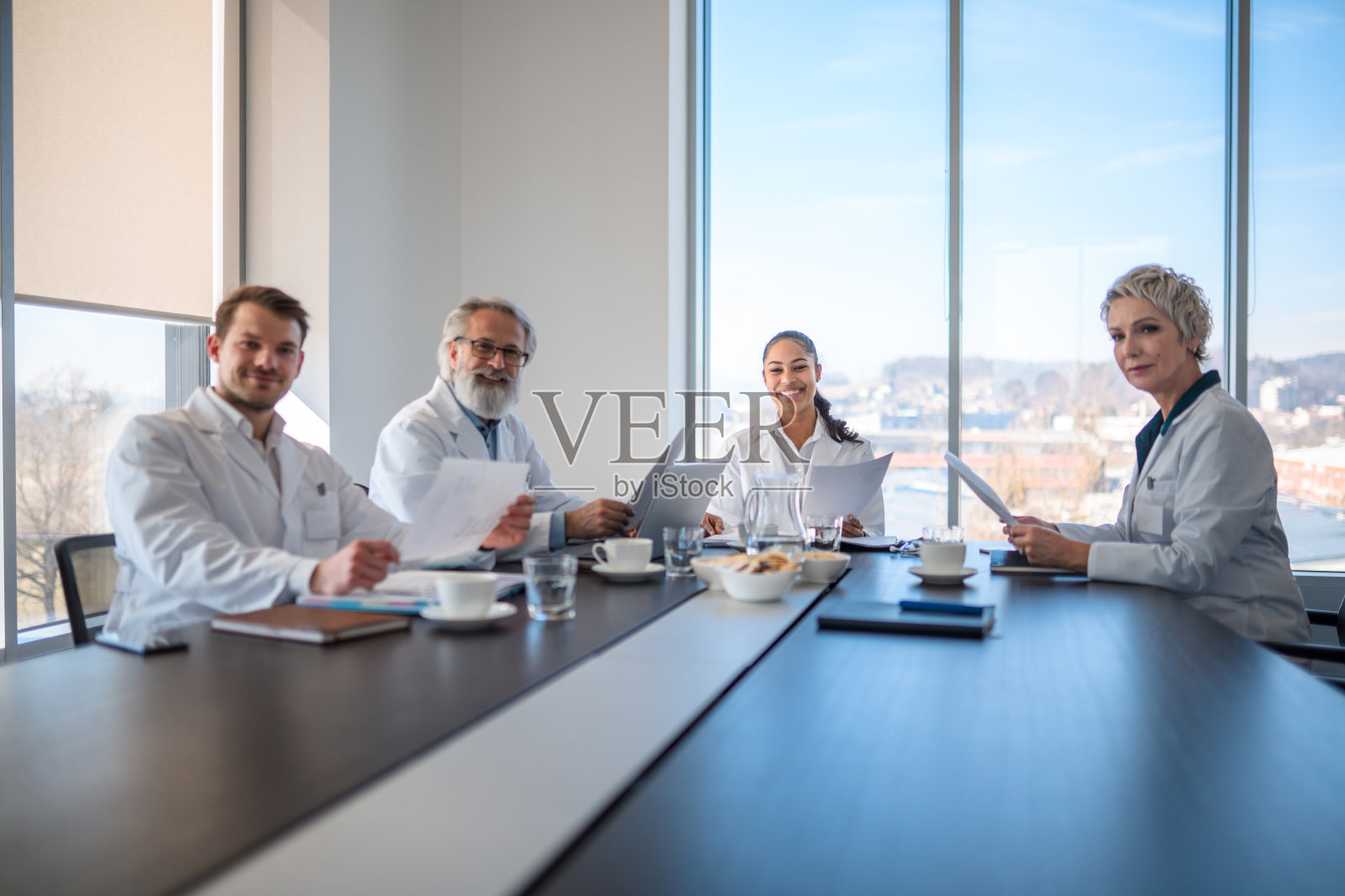 不同的医疗专家在桌子上看着相机照片摄影图片