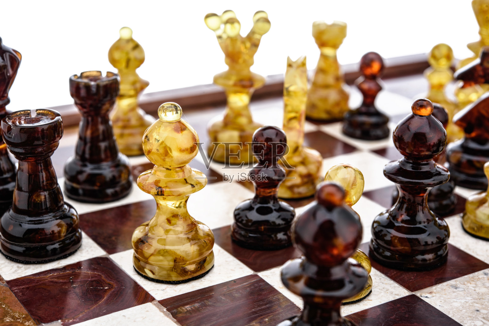 天然琥珀不同的棋子人物站在漆面板上照片摄影图片