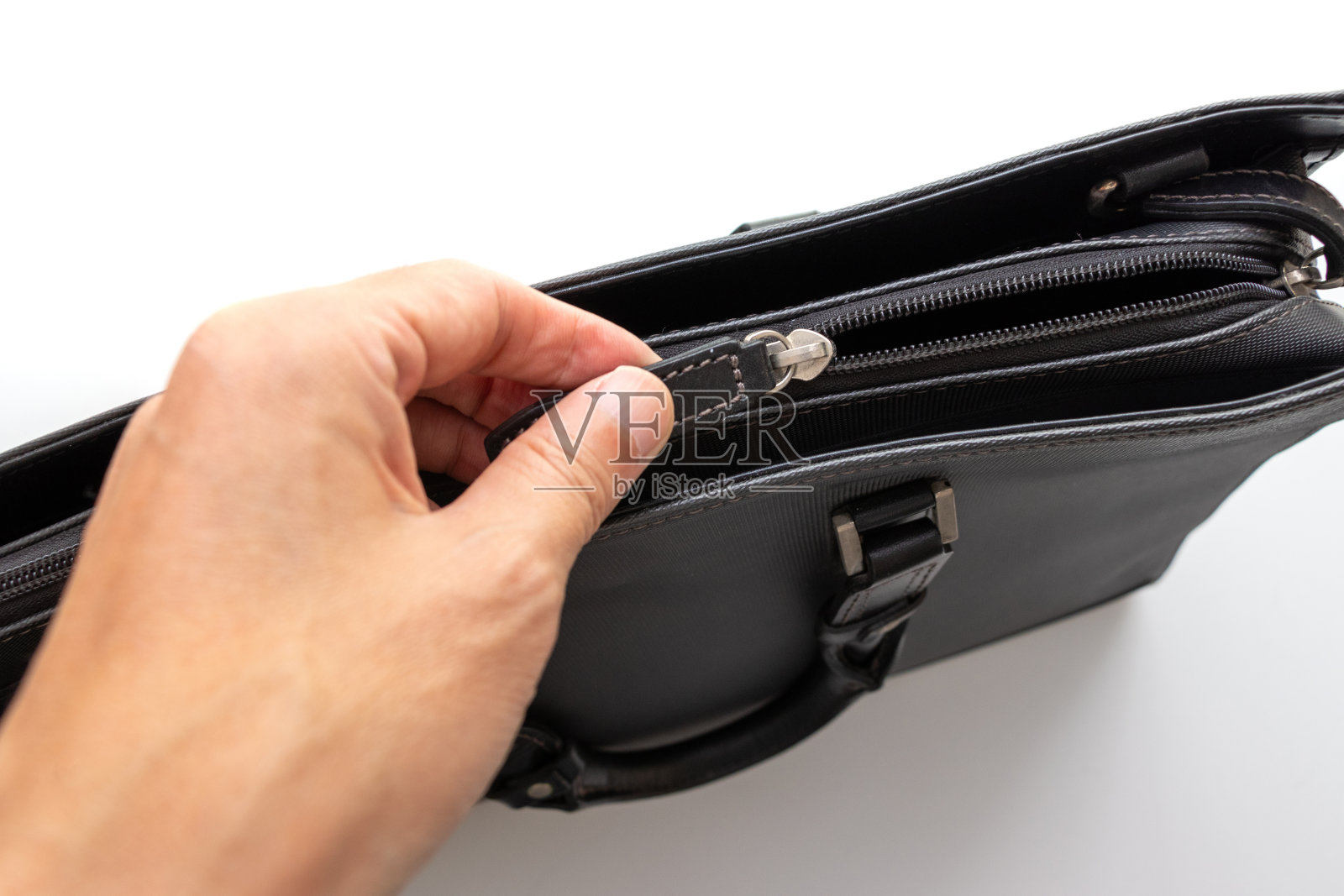 用手打开黑色商务包的拉链照片摄影图片